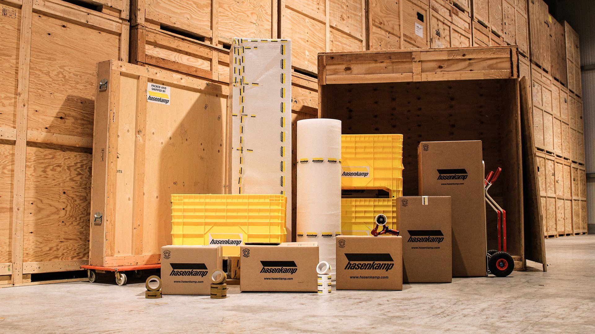 Viele verschiedene Größen von Verpackungen und Transportkisten von hasenkamp stehen in einem großen, hohen Lager.